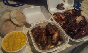 Take out containers with buns, mac & cheese, roast chicken and BBQ ribs