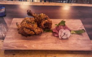 2 pieces of fried chicken with a side garnish of radish and green onion