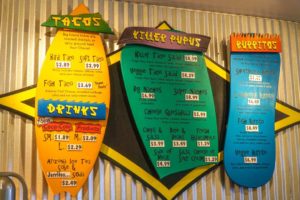 The menu board at Killer Tacos, shaped like surf boards