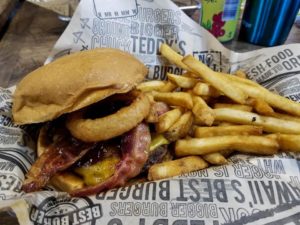 Kilauea Fire burger from Teddy's Bigger Burgers. Burger topped with onion rings, bacon and BBQ sauce, with a side of fries