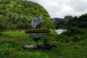 Waimea Valley sign set against the lush green Waimea Valley