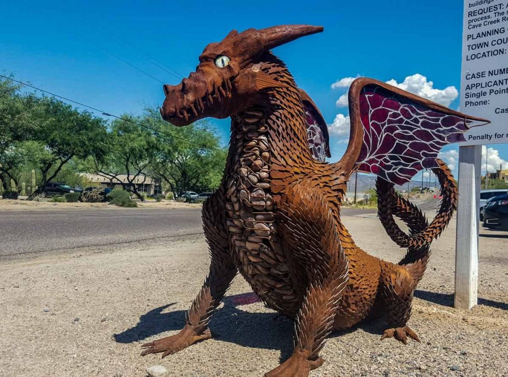 A 4 foot tall metal and rock sculpture in the form of a dragon. 