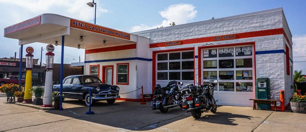 An old-style gas station labelled 'Pete's Gas Station Museum' with a car and 2 motorcycles parked out front